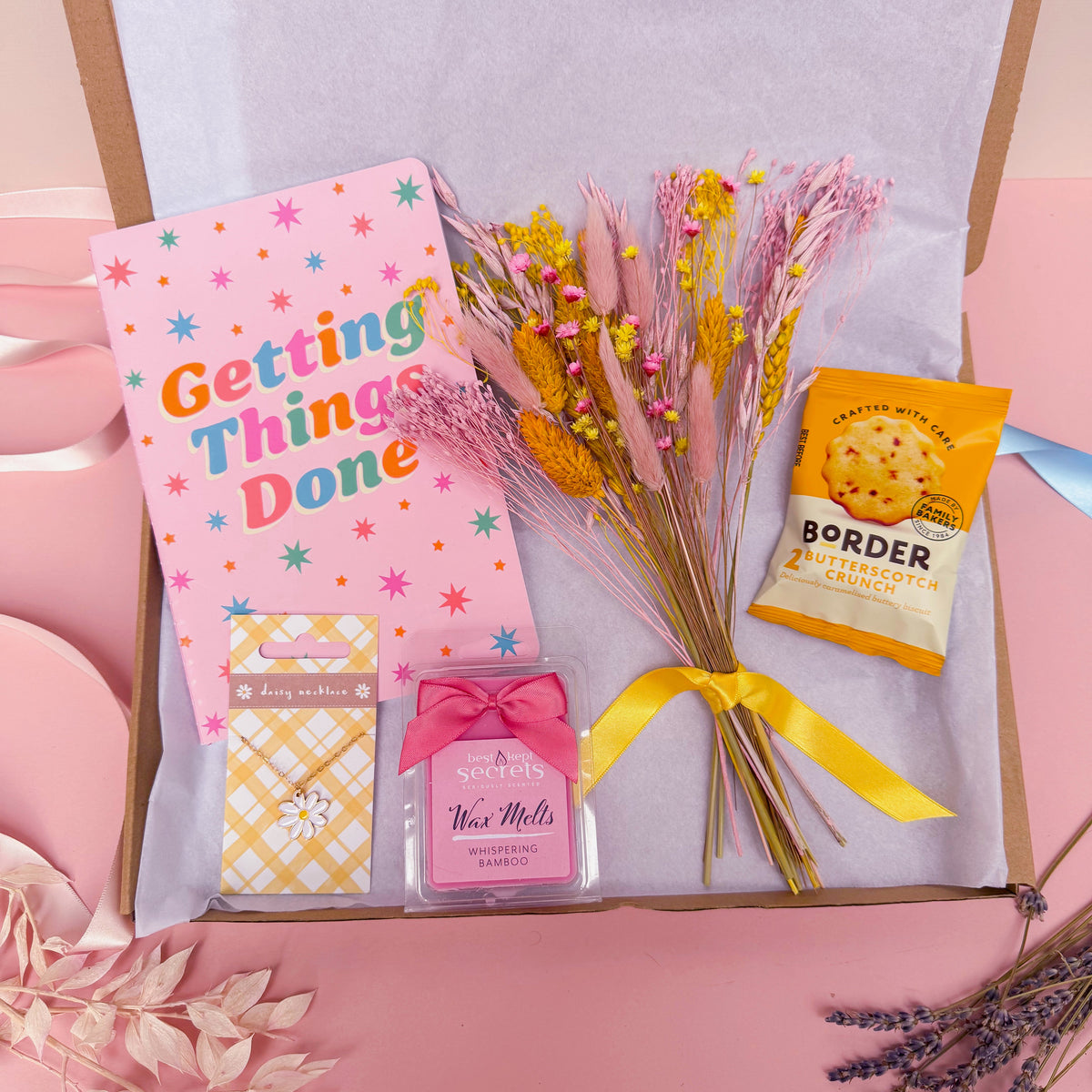 Letterbox gift with stationery, dried flowers, wax melts, biscuits and jewellery in pink and yellow colours