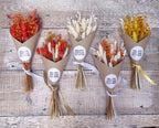 small autumnal dried flower arrangements wrapped in brown paper and hand tied with ribbons, displayed against a wooden background