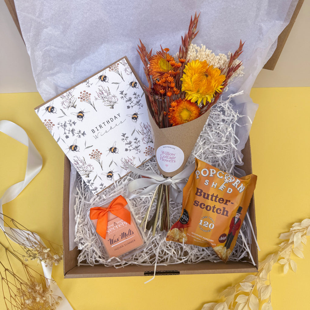 Birthday Gift box with flowers, card and popcorn on a yellow background