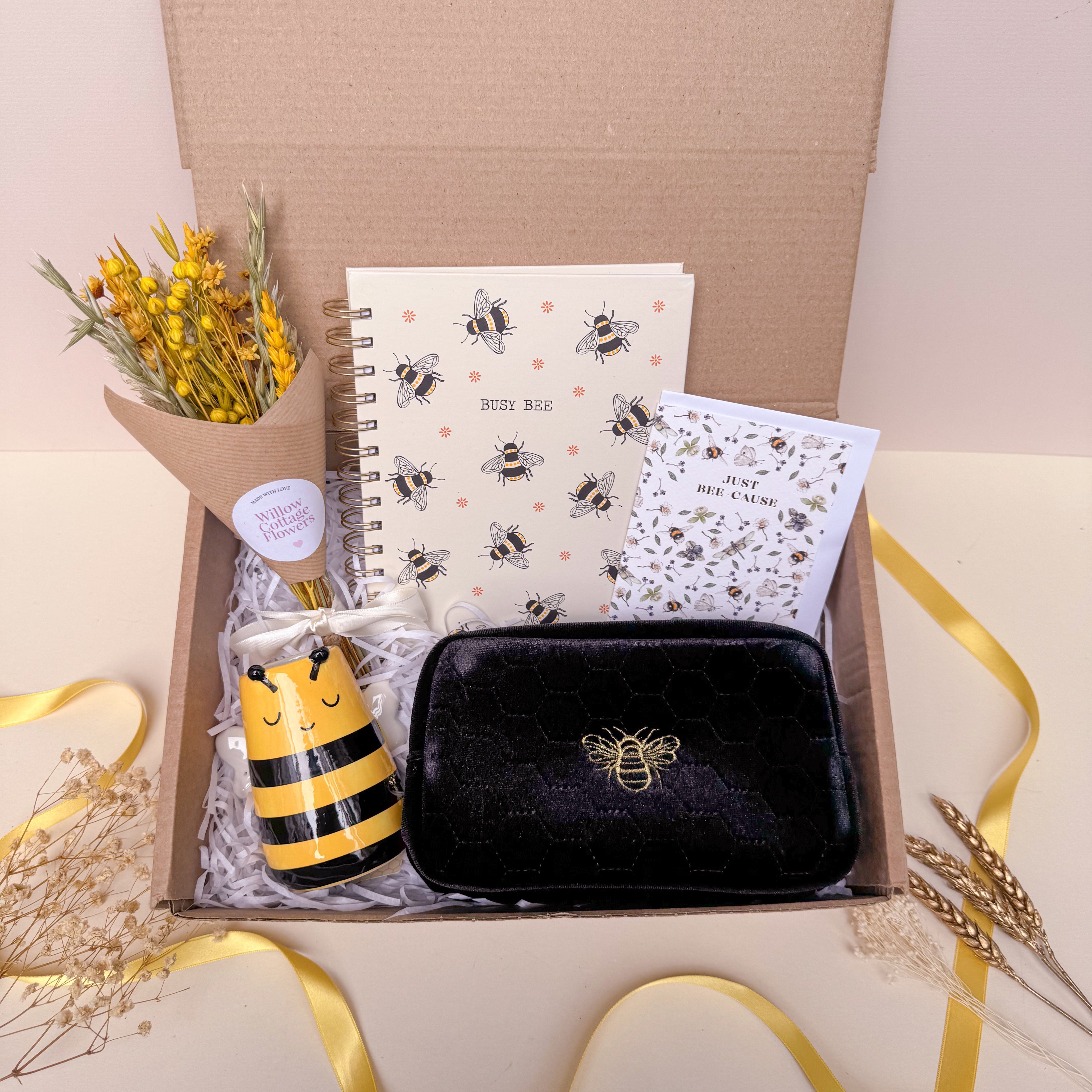 gift set with bee themed items including notebook, dried flowers, card, vase and makeup bag