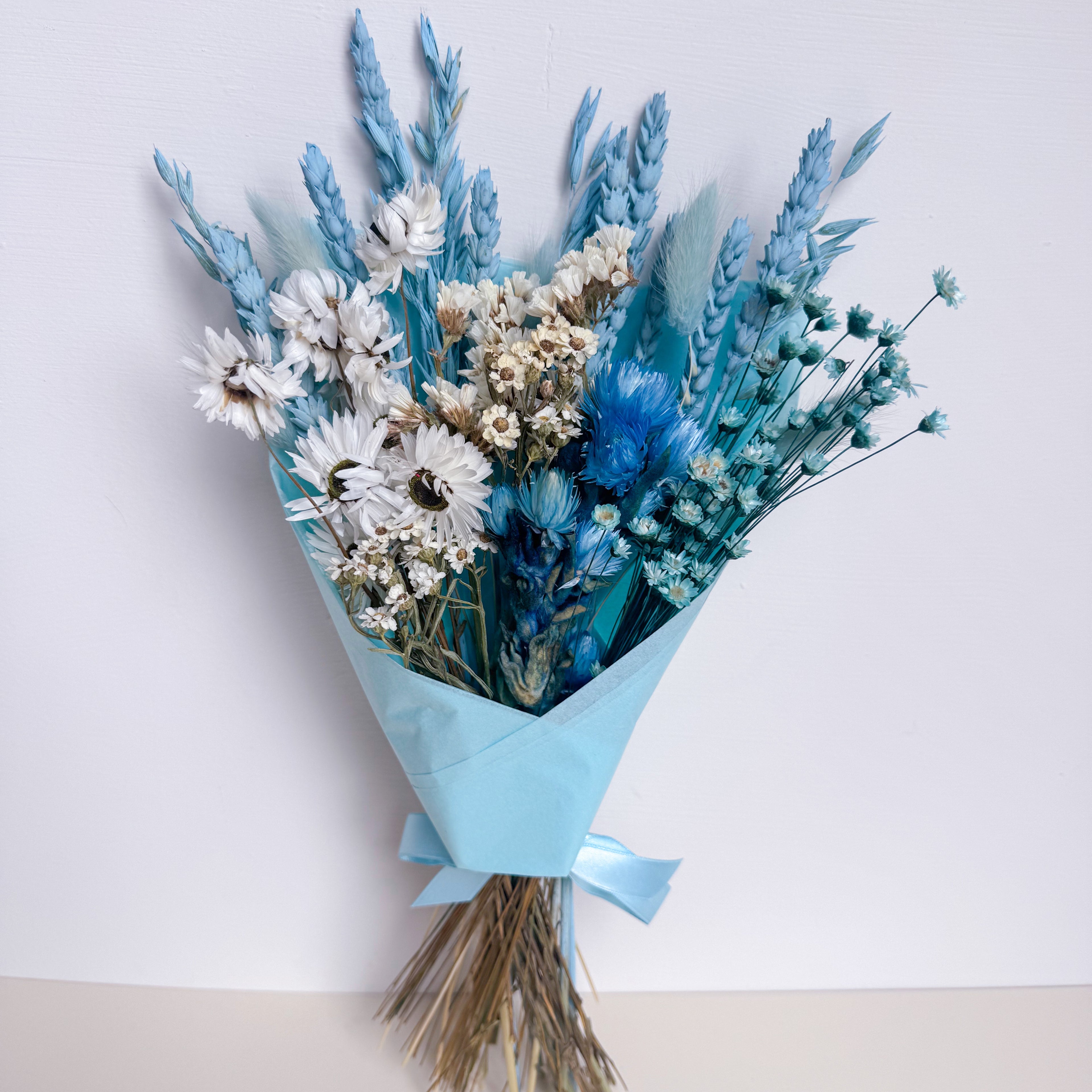 blue and white dried flower bouquet with white daisies