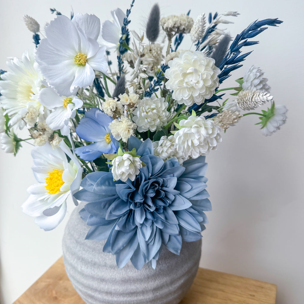 white faux flower arrangement in rustic vase
