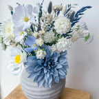 white faux flower arrangement in rustic vase