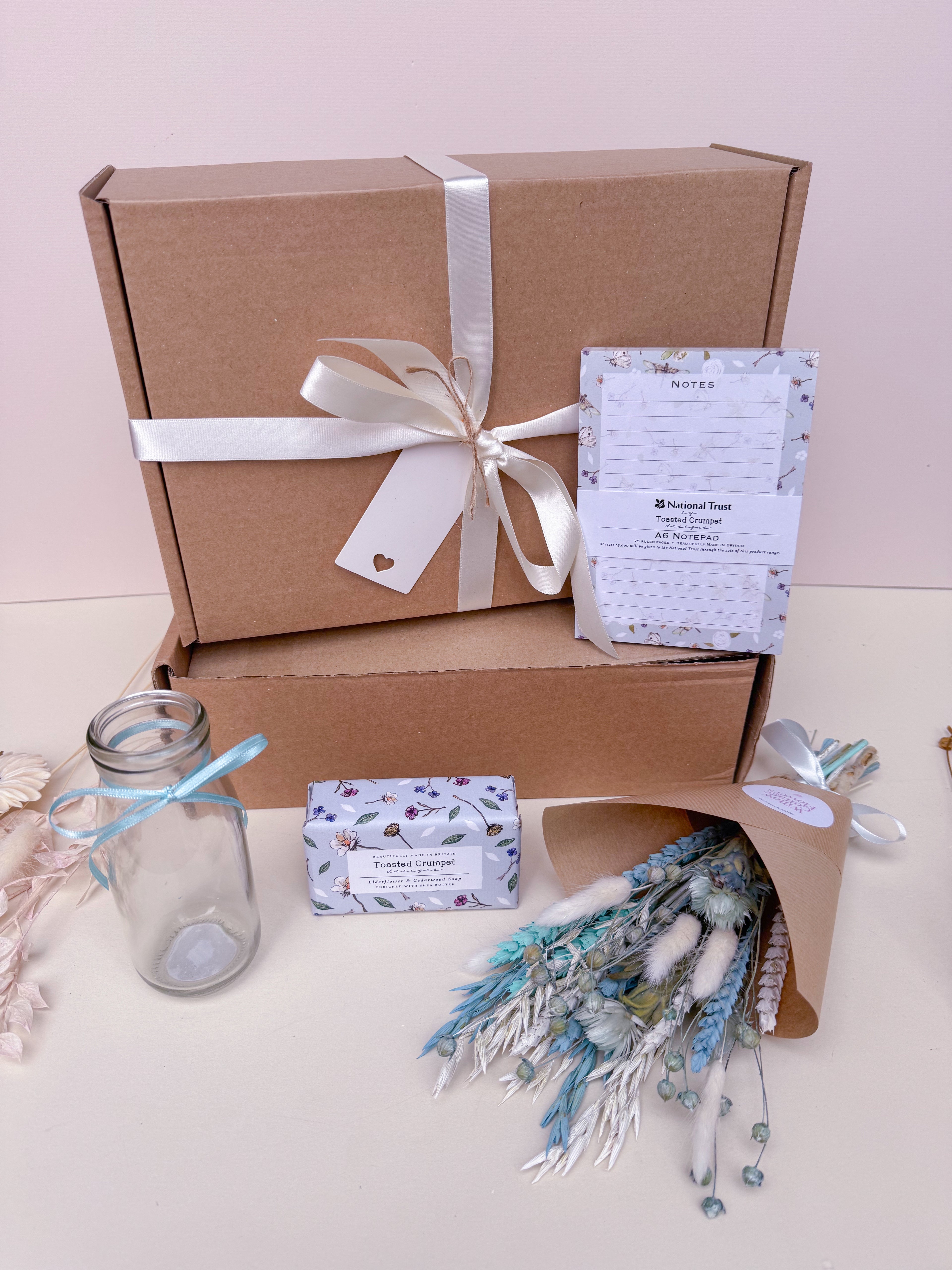 blue themed gift hamper with dried flowers, soap, notebook and vase