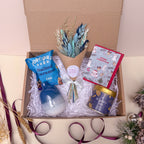 Gift box with a bouquet, card, and other christmas items on a light background