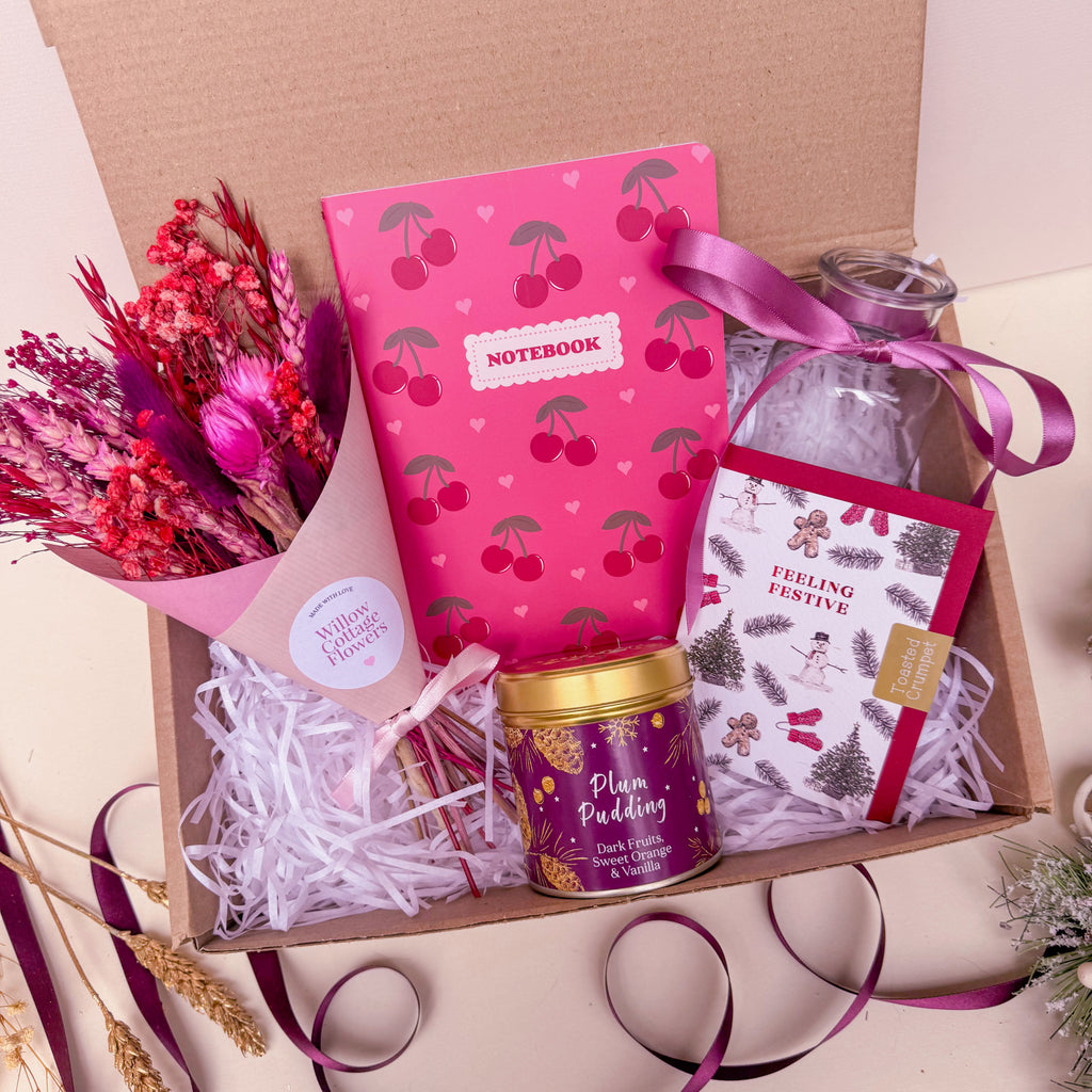Christmas gift box with a pink cherry notebook, plum pudding candle and pink dried flower bunch