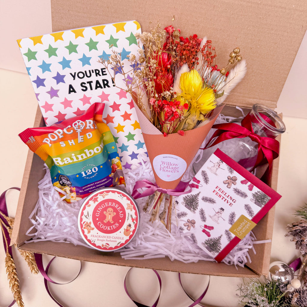 Gift box with flowers, popcorn, gingerbread candle, and card 