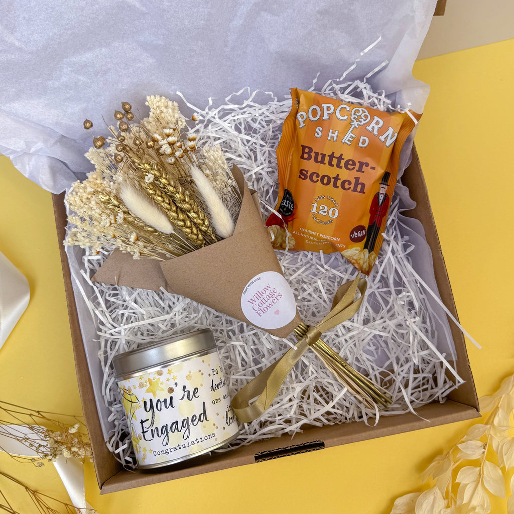 Gift box with 'You're Engaged' candle, popcorn and dried flower bunch.