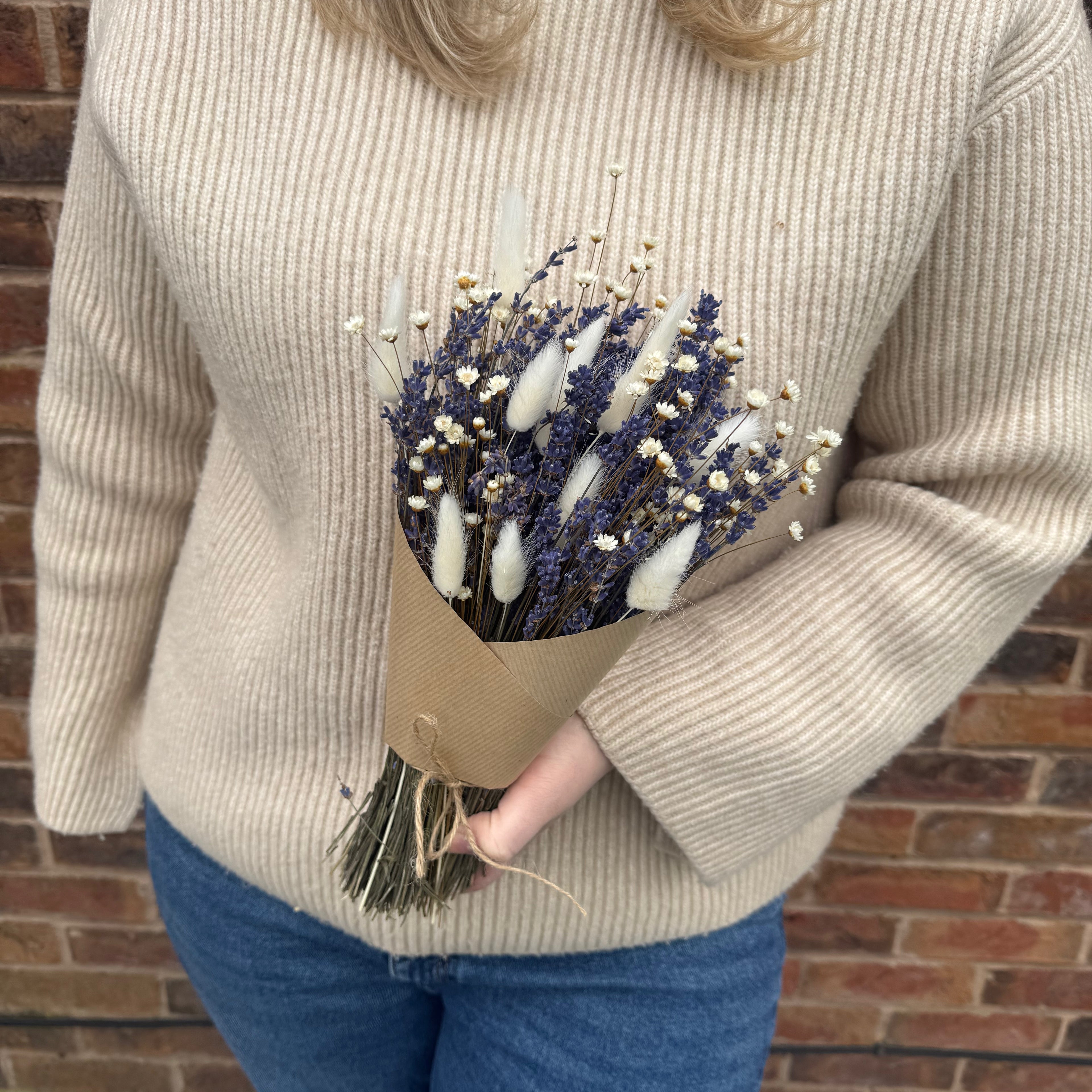 lavender bouquet being held in brown paper