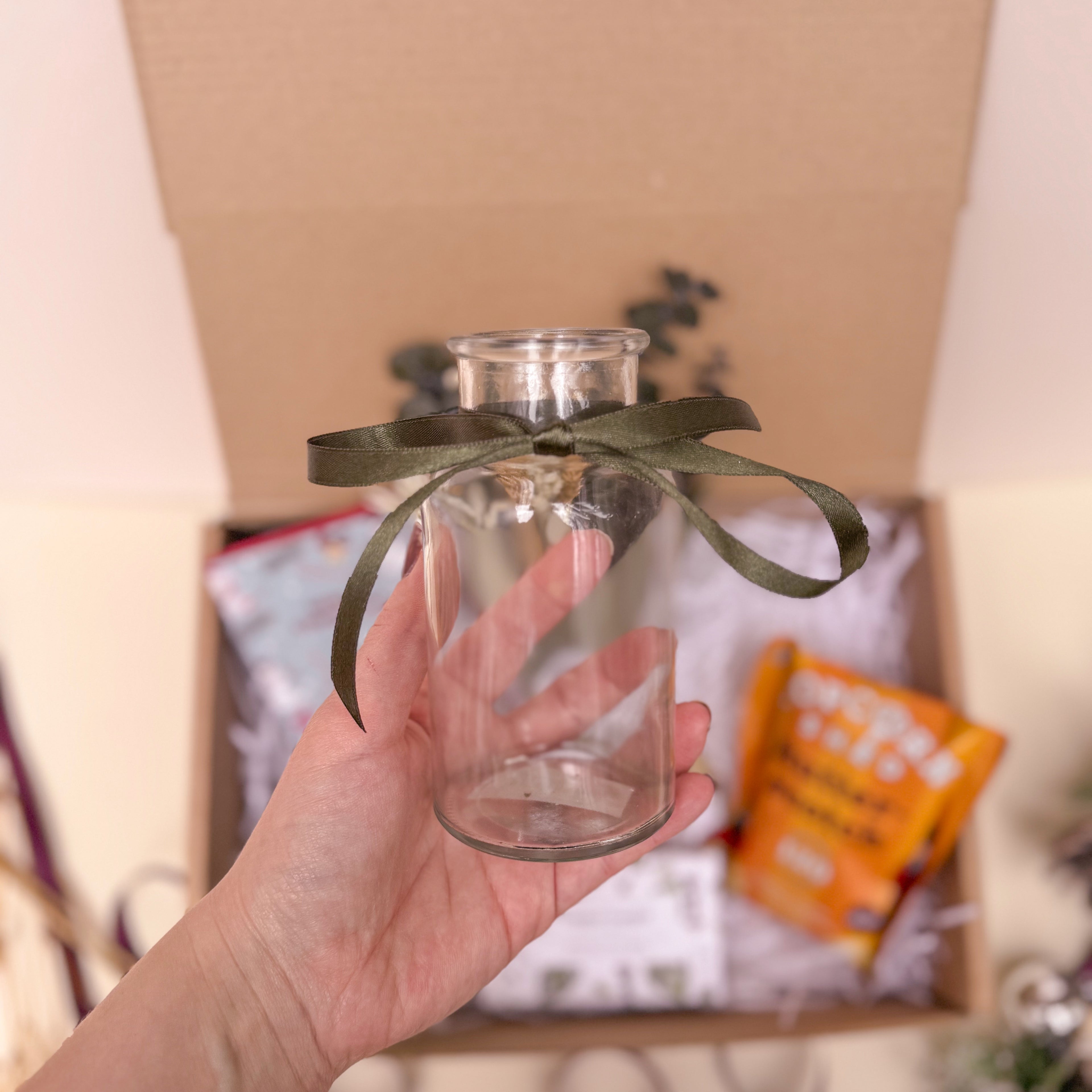 glass vase with dark green ribbon
