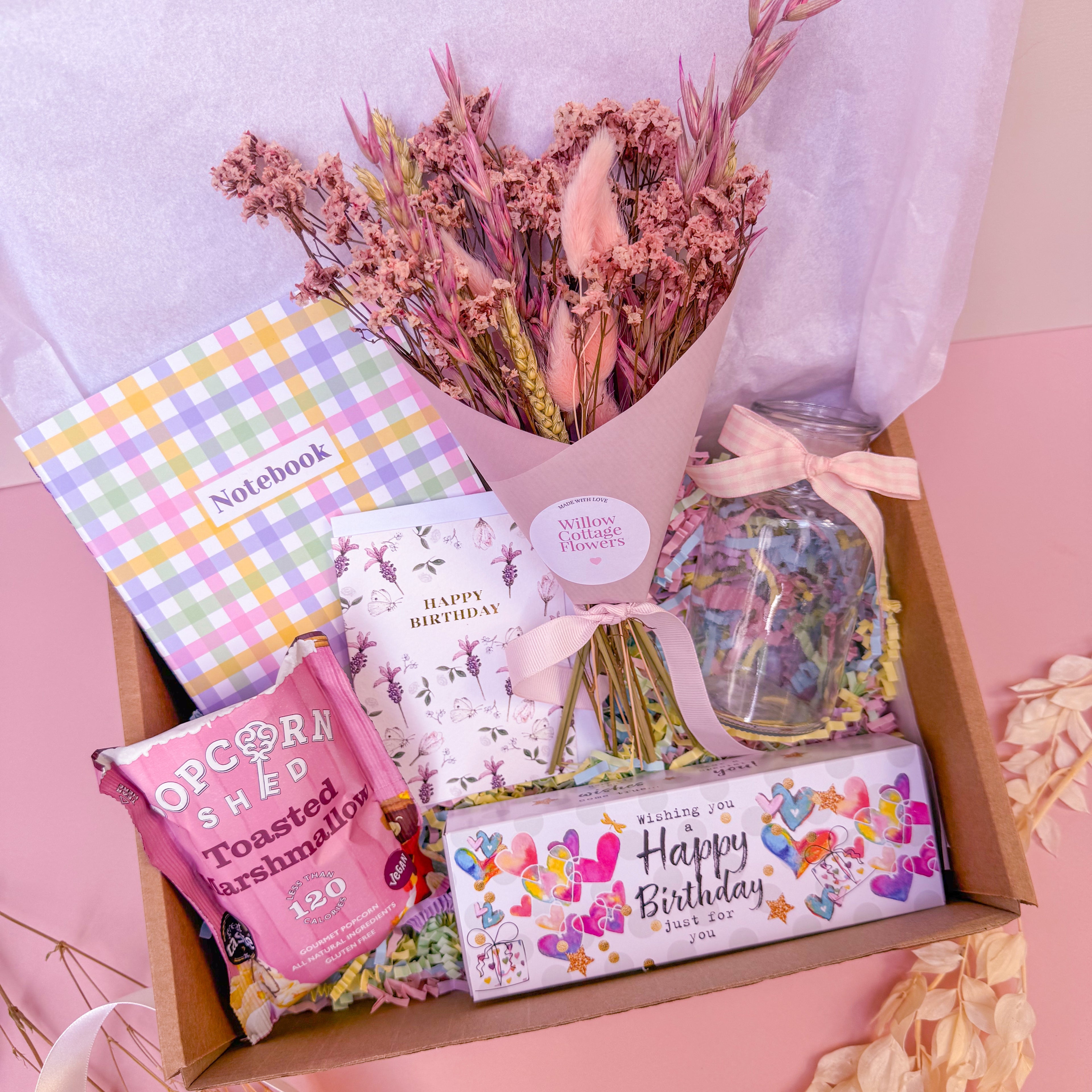 birthday gift box in pink with dried flowers, luxury candles, popcorn and notebook