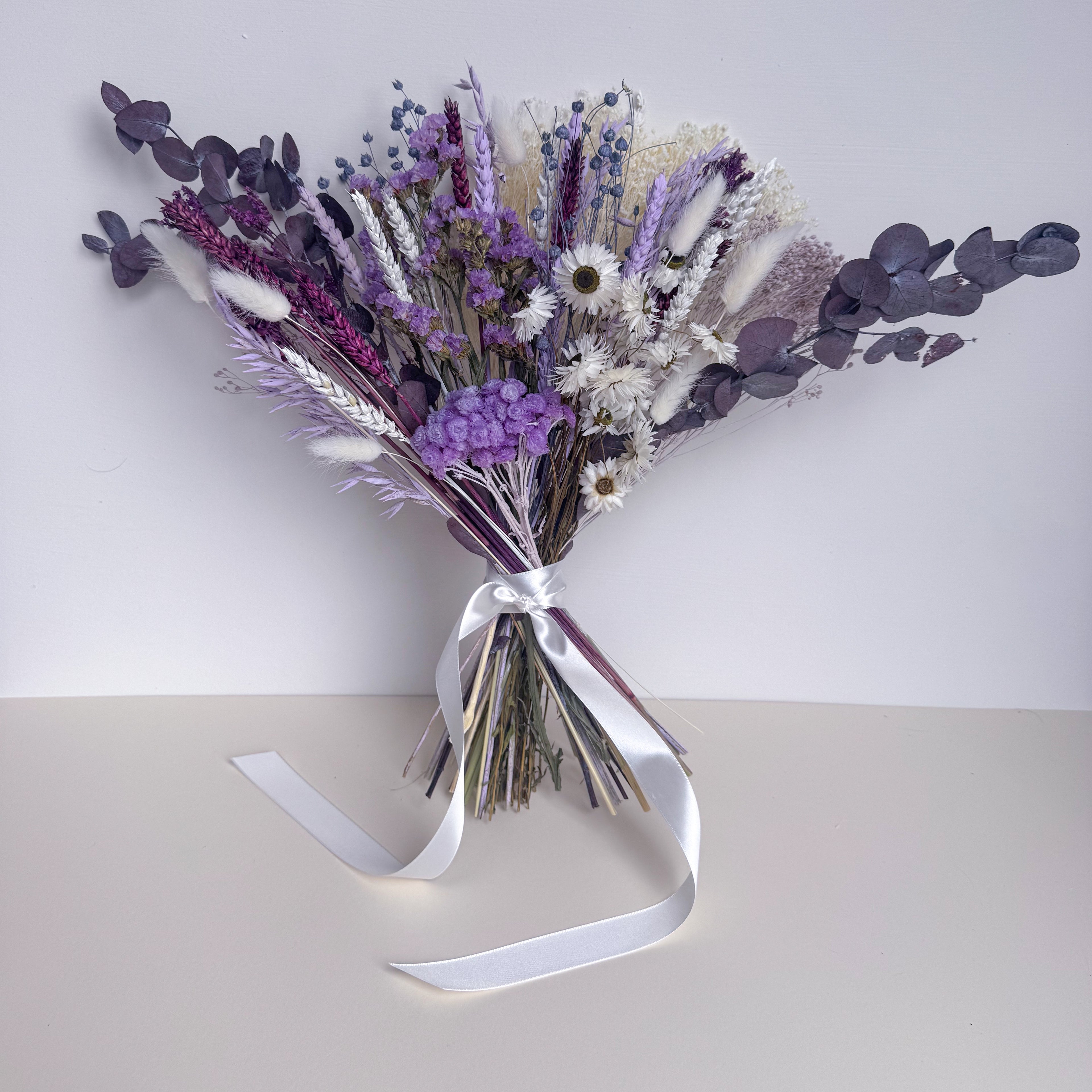 dark purple dried flower arrangement with daisies