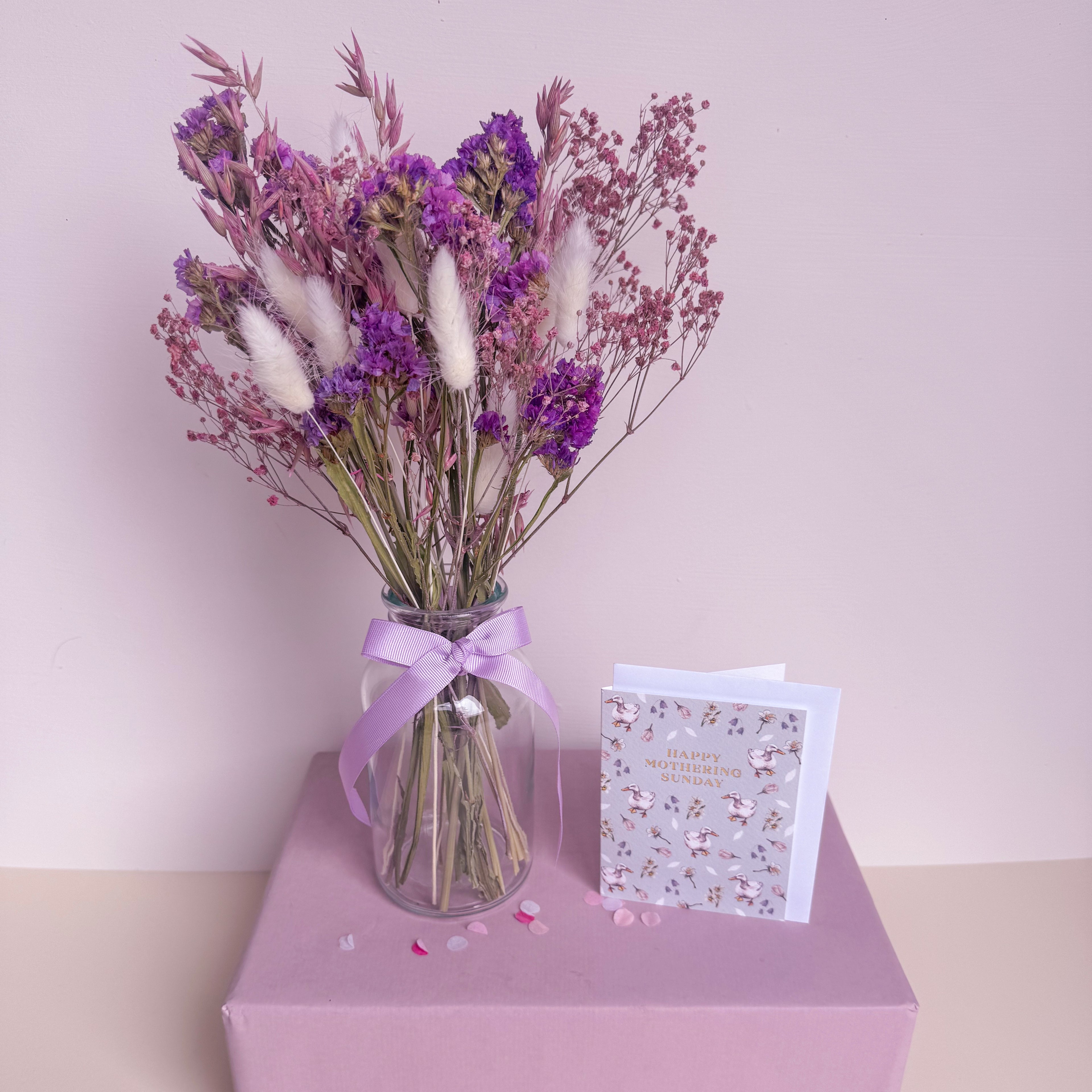 purple statice arrangement with glass vase and mothers day card