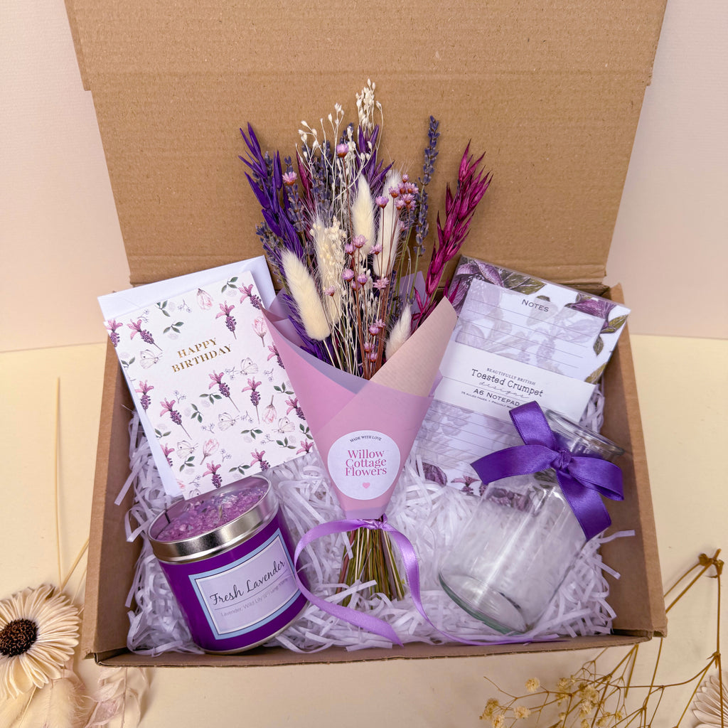 Gift set with lavender themed items including a bouquet, candle, notebook and card.