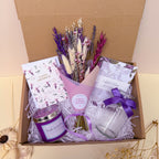 Gift set with lavender themed items including a bouquet, candle, notebook and card.
