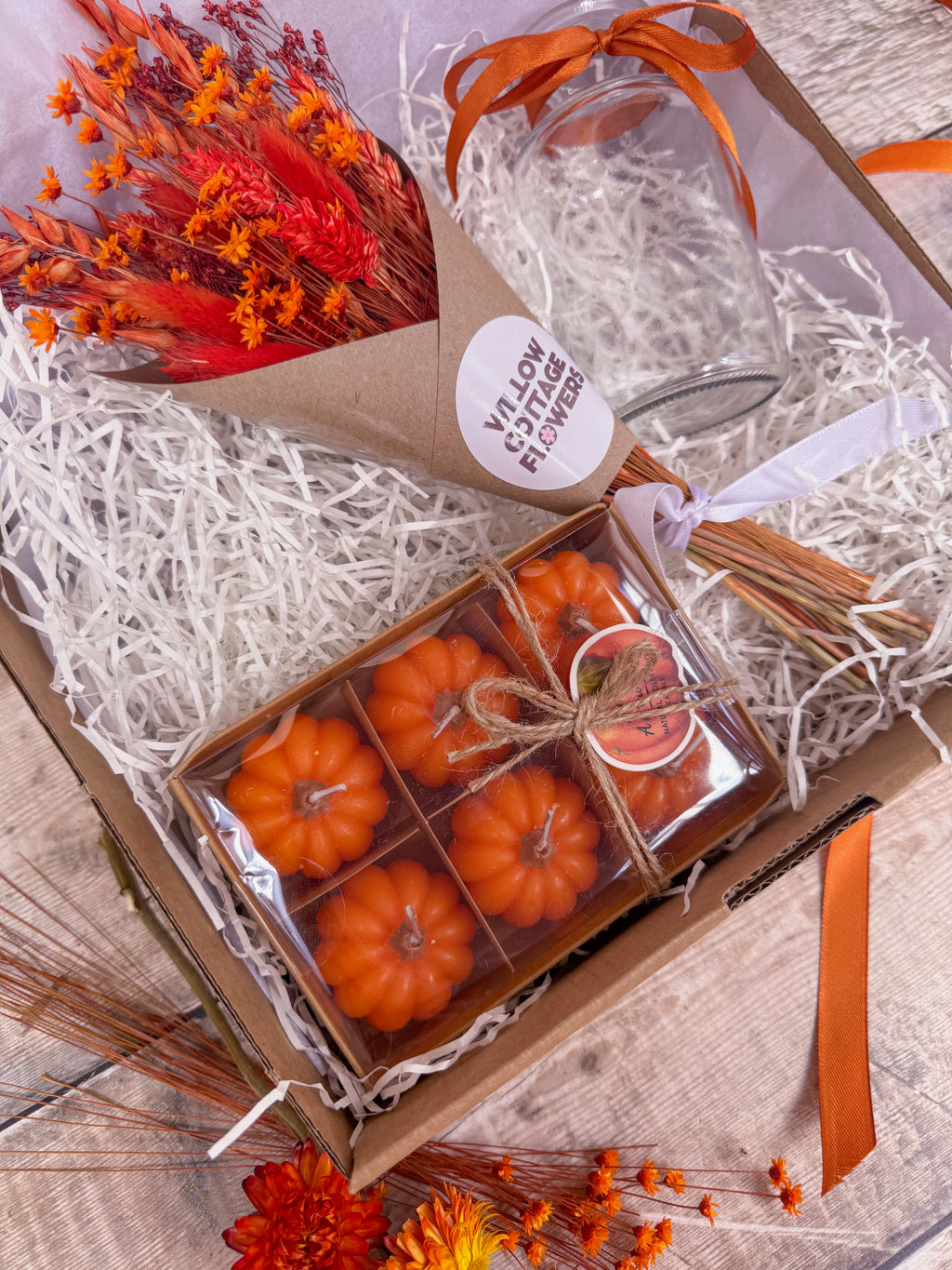 autumn themed gift hamper with pumpkin candles, vase and orange dry flower bouquet