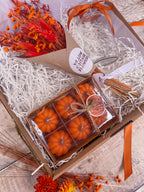 autumn themed gift hamper with pumpkin candles, vase and orange dry flower bouquet