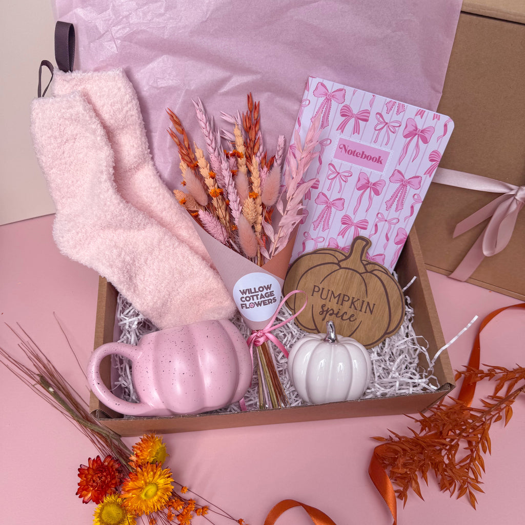 pink autumn themed gift hamper with pumpkin mug, dried flowers, pink cosy socks, bow notebook and white pumpkin ornament