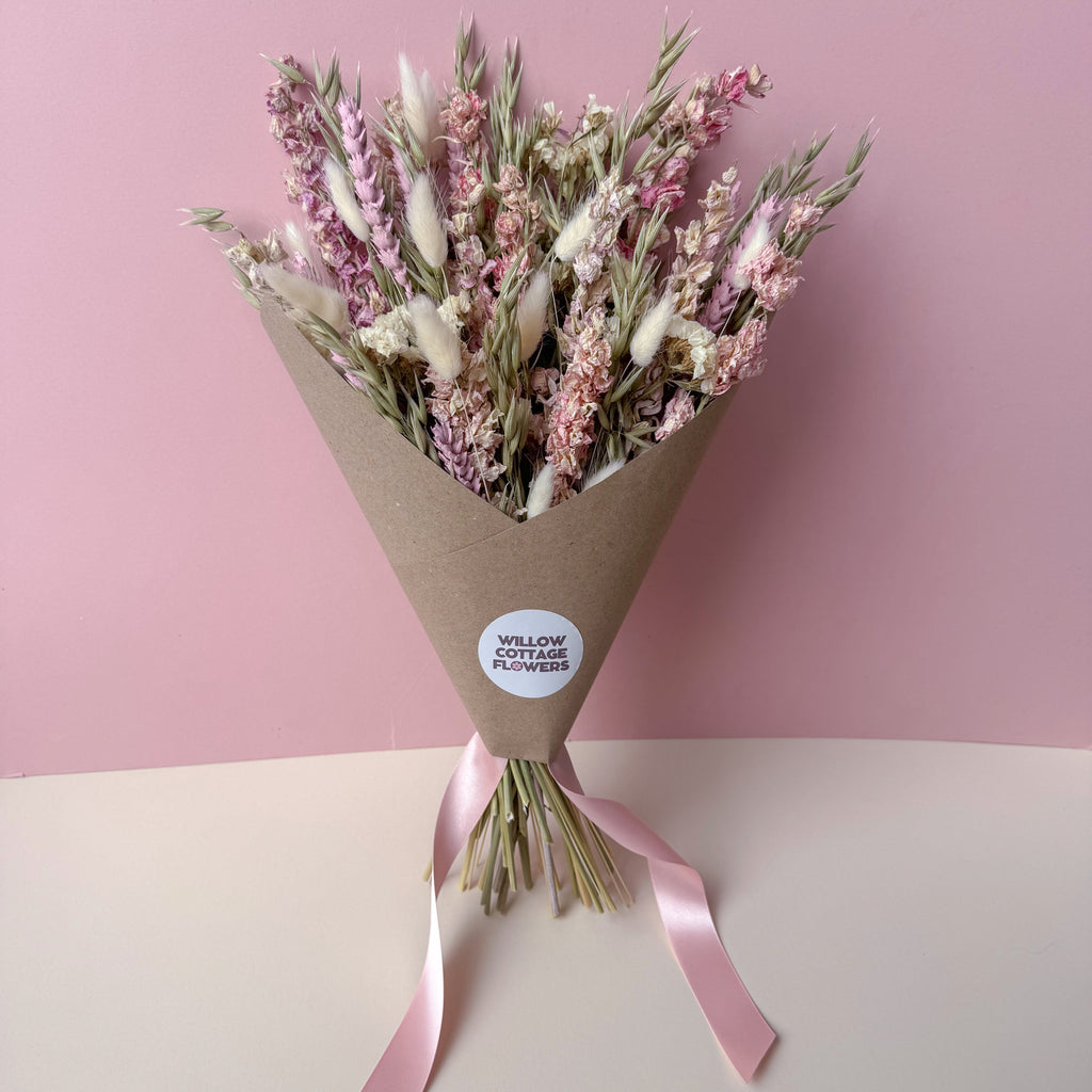 a pink delphinium dried flower arrangement with sage green accents
