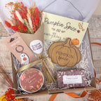an autumn curated gift box with autumn goodies including dried flowers, autumn spice candle, luxury soap bar, pumpkin wooden coaster and ghost keychain.