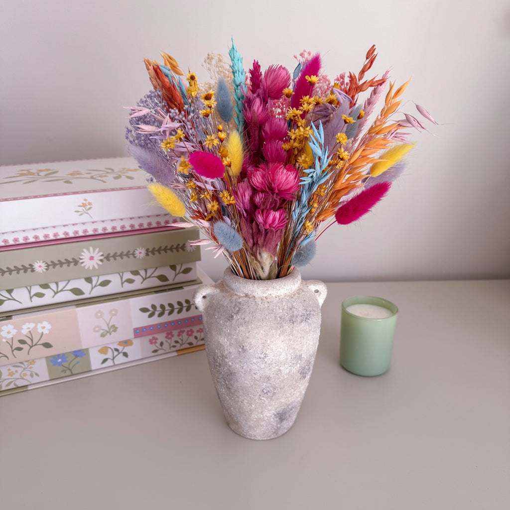 small rainbow dried flower bunch displayed in a rustic vase