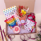 rainbow gift box with dried flowers and festive candle