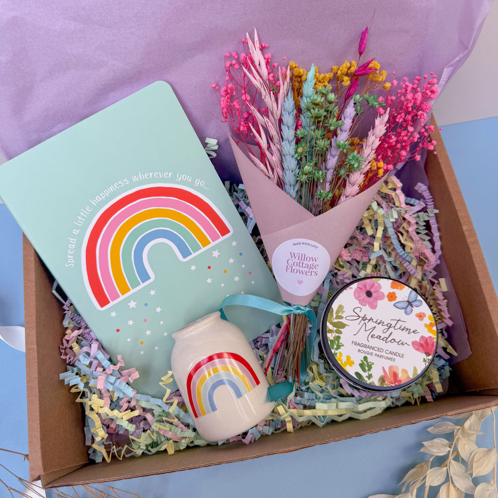 Rainbow gift set with a notebook, candle, and flowers in a box