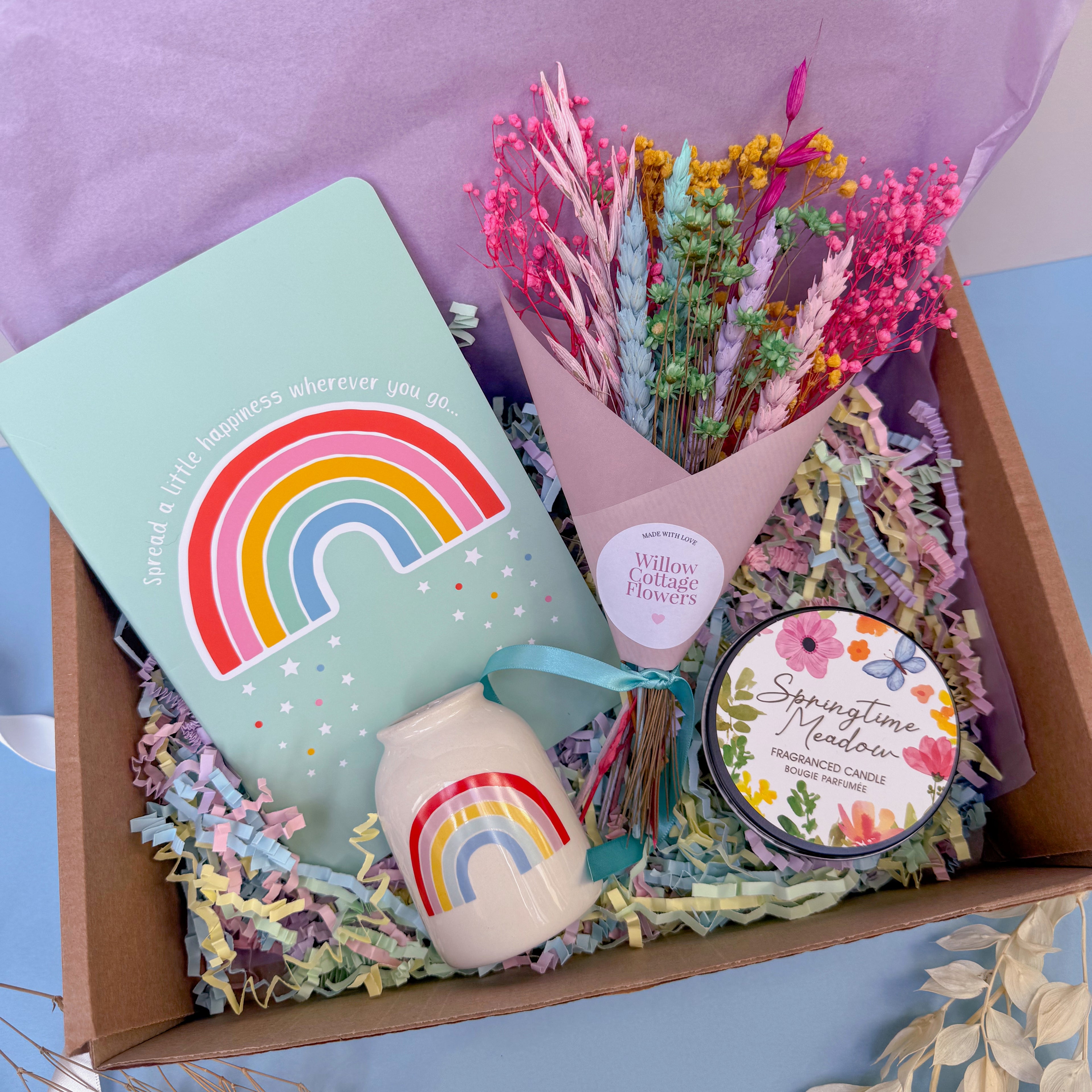 Rainbow gift set with a notebook, candle, and flowers in a box