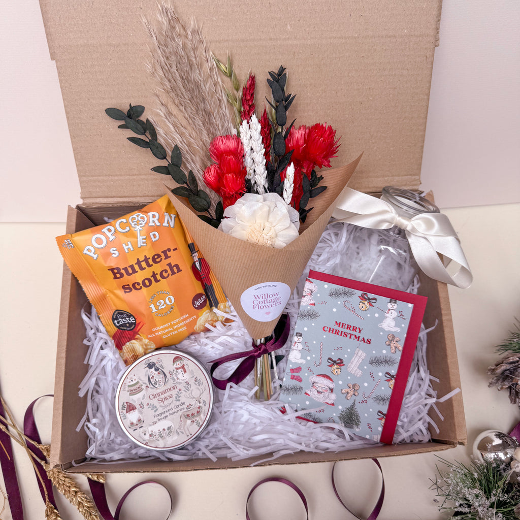 festive gift box with flowers, popcorn, candle and vase