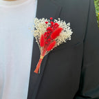 red and white dried flower buttonhole on suit