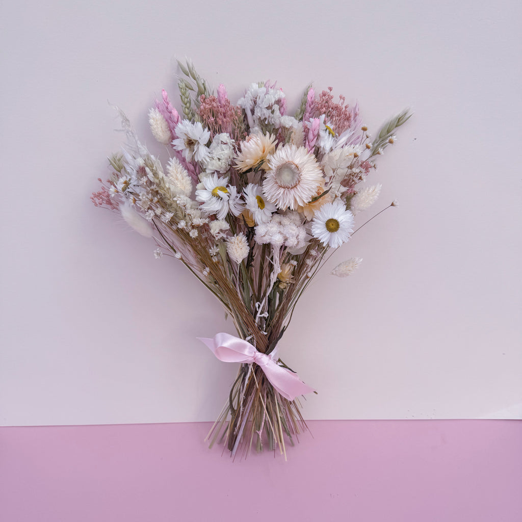 small flower girl dried flower bouquet with daisies, strawflowers, oats and wheat in pink, green and white tones.
