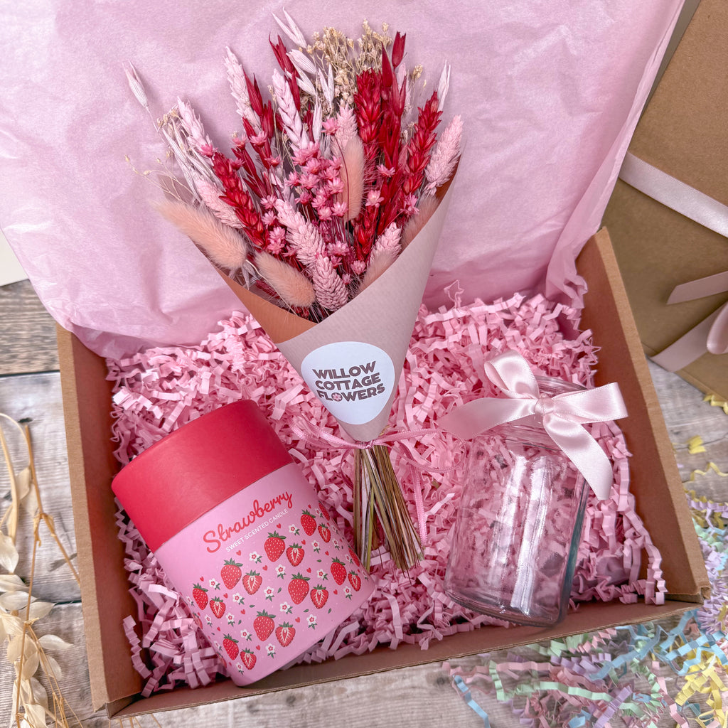 a strawberry themed gift box with dried flowers, glass vase and strawberry scented candle