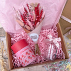 a strawberry themed gift box with dried flowers, glass vase and strawberry scented candle