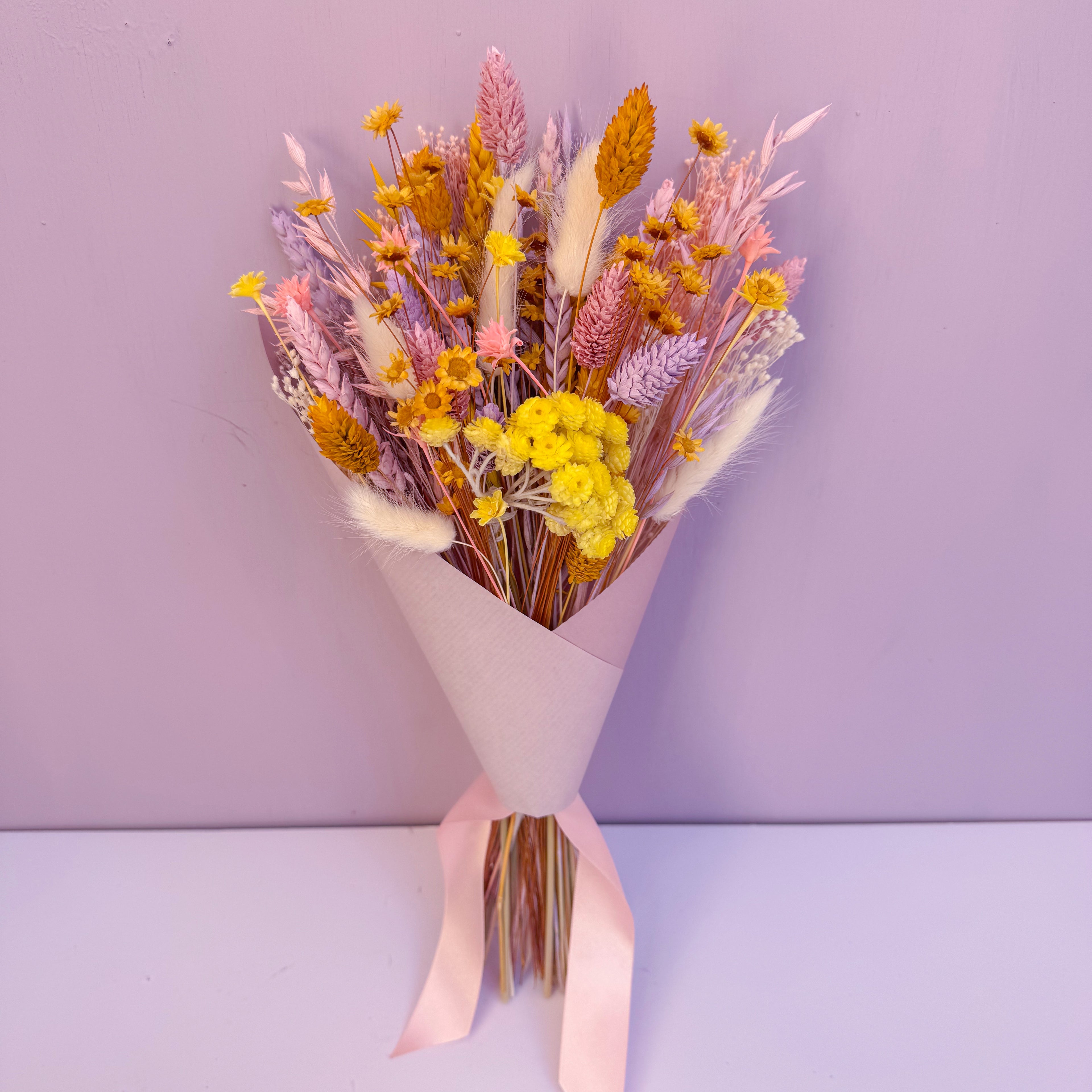 mini bunch of colourful boho dried flowers wrapped in pink paper