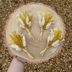 spring yellow dried flower buttonhole on wood background