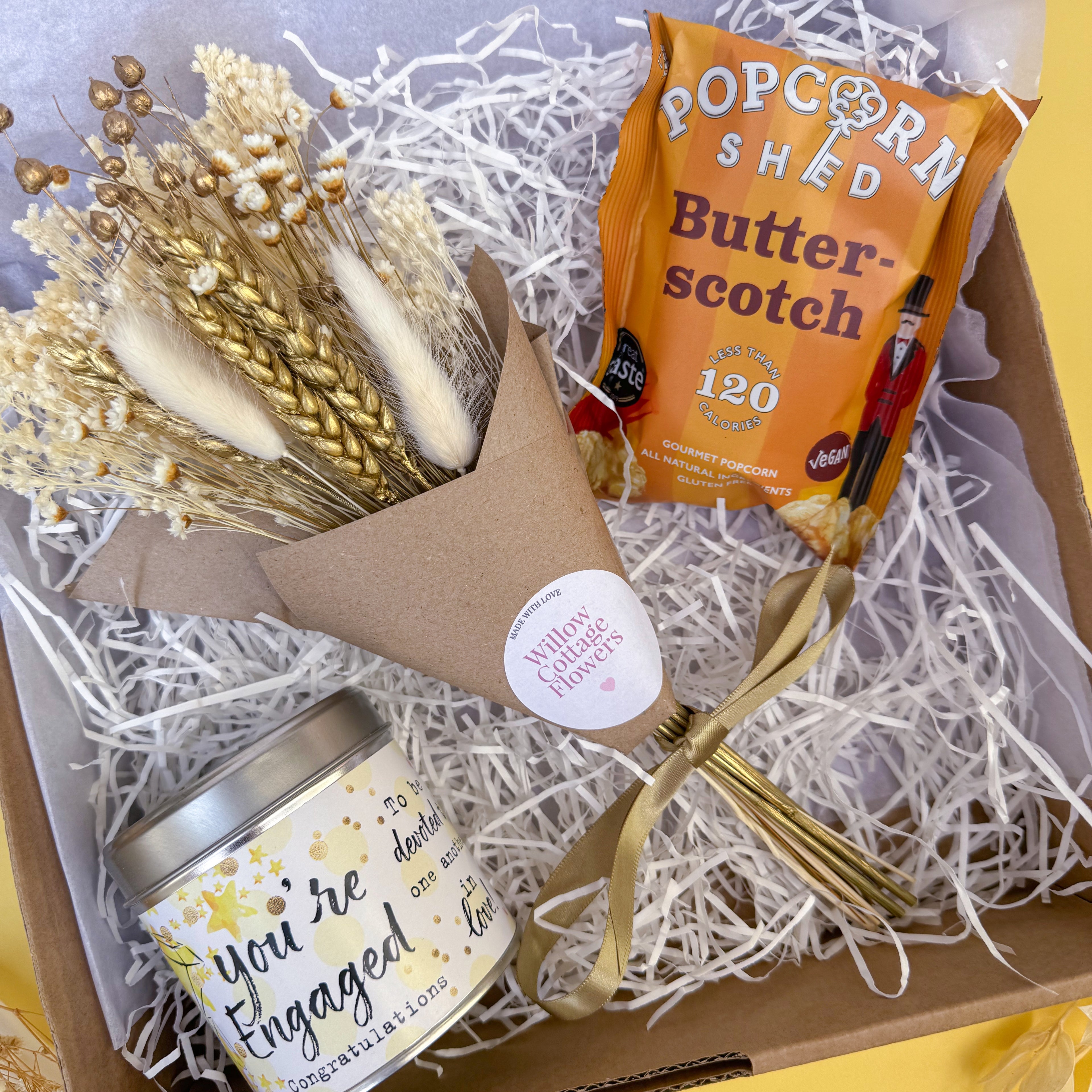 Gift set for engagement with bouquet, candle, and popcorn in a box